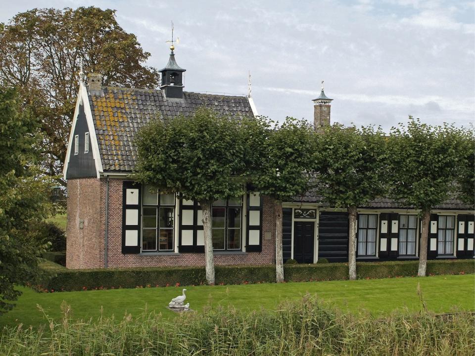 Noorderpolderhuis buitenaanzicht met gemaaid gras